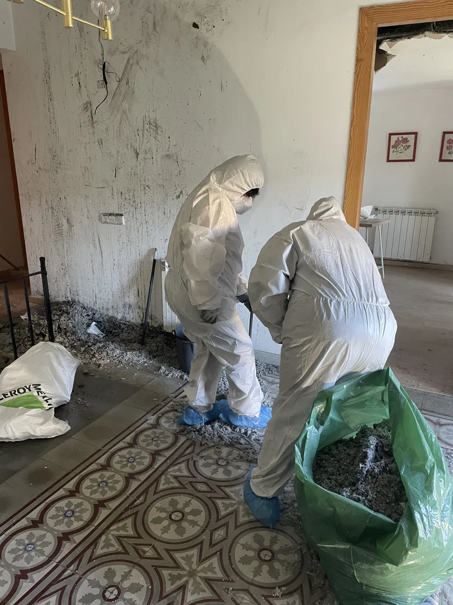 Especialistas en limpieza técnica y retirada de residuos tóxicos Equipo profesional de limpieza post incendio con trajes de seguridad EPIS retirando residuos