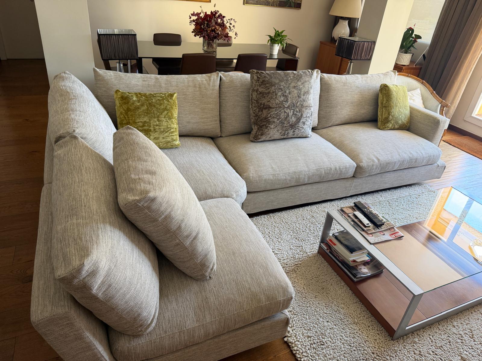 Sofá modular de lujo de algodón y plumas en un salón de Barcelona, impecable tras un servicio de limpieza profesional en seco