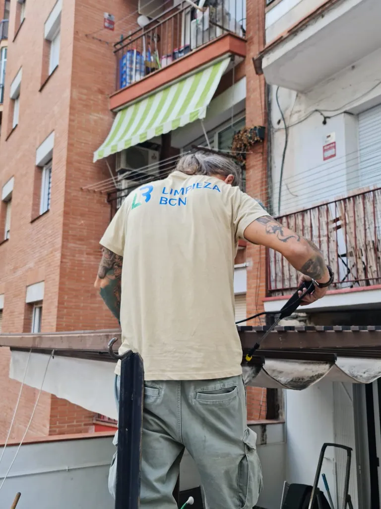 Trabajador de Limpieza BCN limpiando un toldo a domicilio con maquinaria profesional