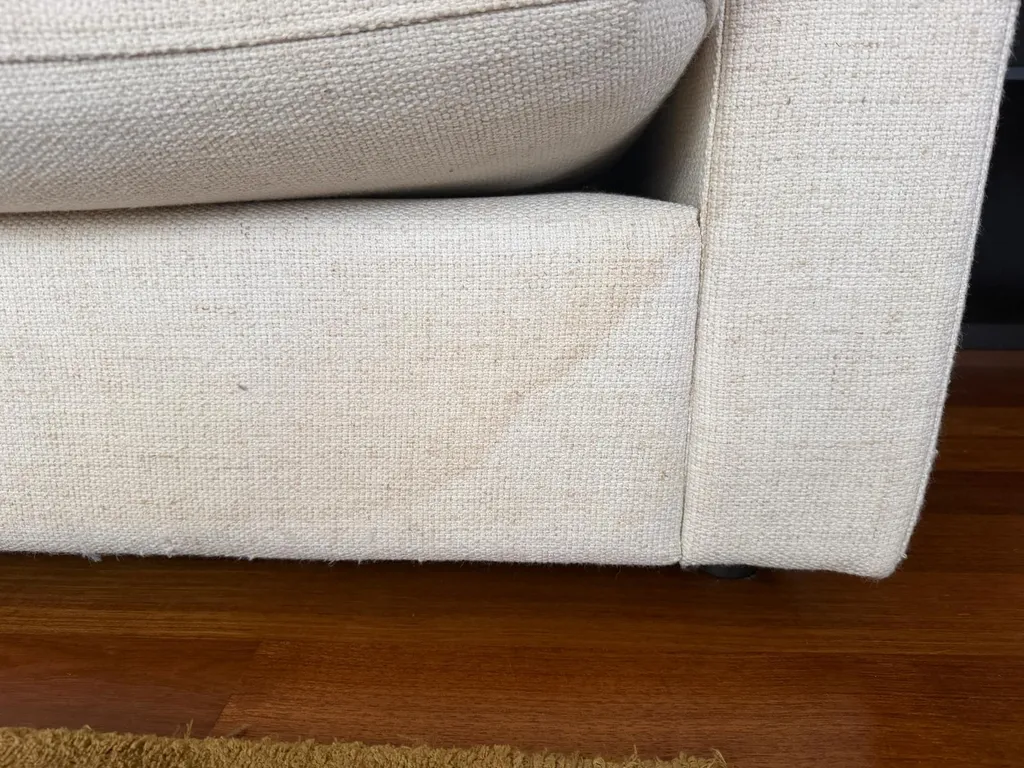Manchas marrones de taninos en un sofá de lino tras una limpieza incorrecta con agua