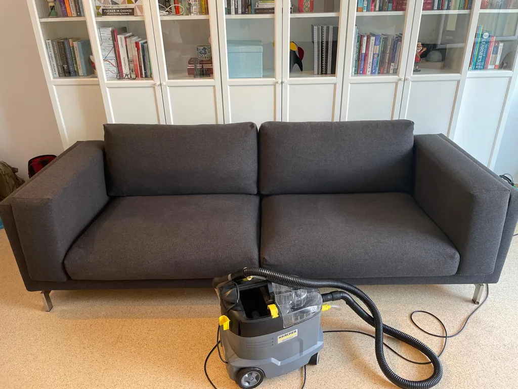 Técnico de Limpieza BCN realizando una desinfección profunda de sofá gris con máquina Kärcher de inyección-extracción en Barcelona.