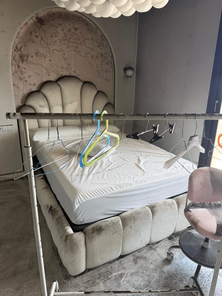 Perchero con colgadores de ropa y cama expuestos a una densa capa de humo y hollín negro en un dormitorio tras un incendio